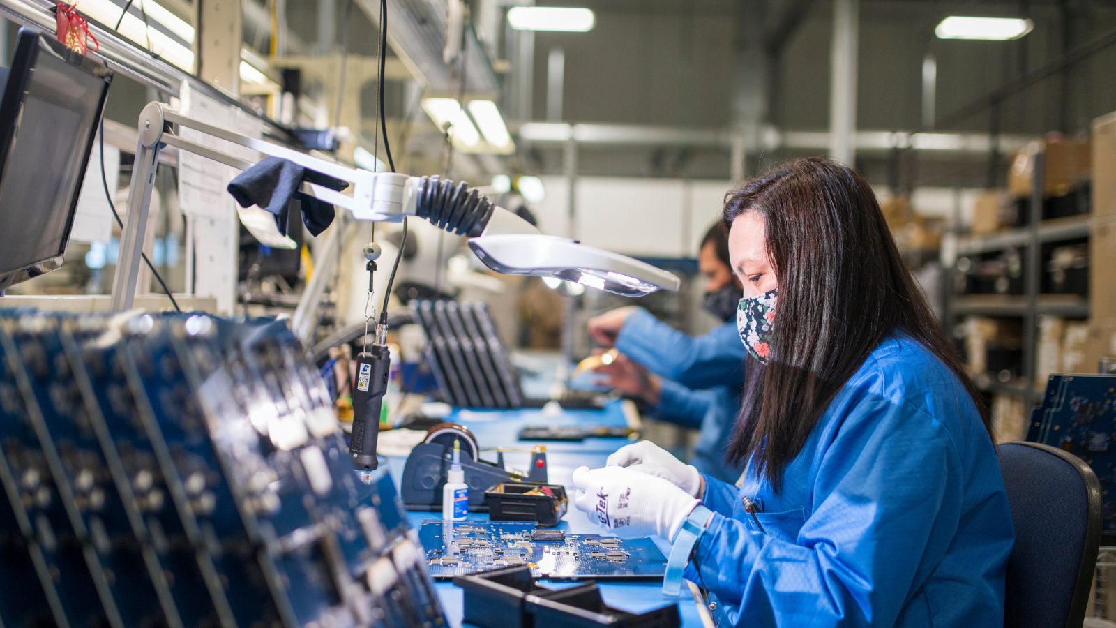 Production staff in the manufacturing facility working on PCBs.