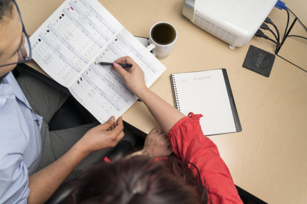 Engineering and supply chain professionals reviewing manufacturing documentation during a supply chain planning meeting for electronics manufacturing.